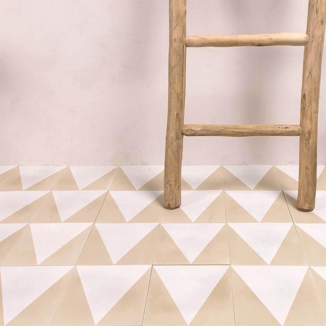 Beige and white geometric triangle pattern on a floor with a wooden ladder against a beige wall.
