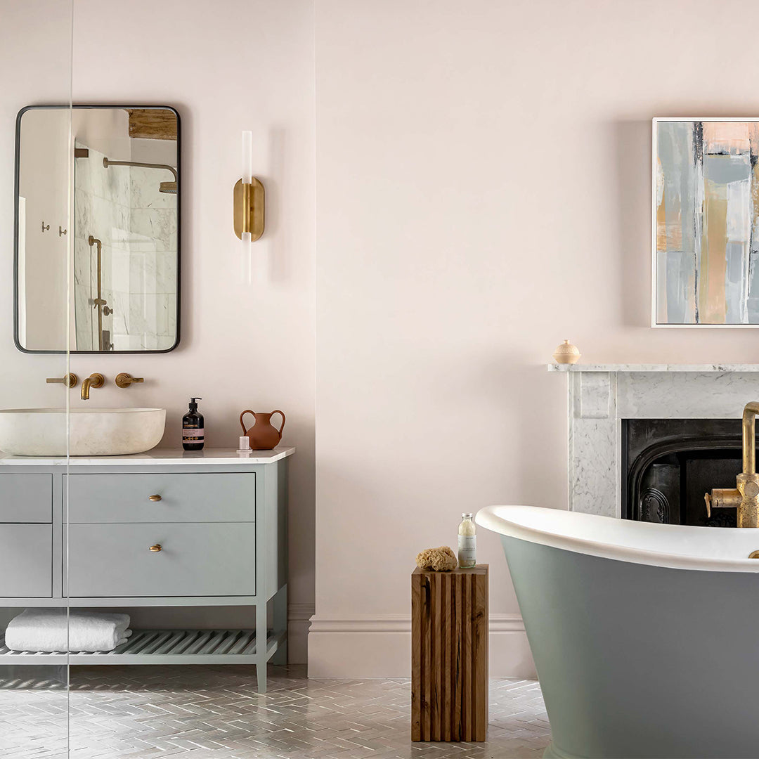 Modern bathroom with freestanding bathtub, vanity, and abstract art on wall.