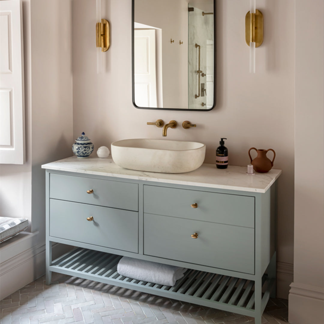 Bathroom vanity with a sink, drawers, and decorative items.