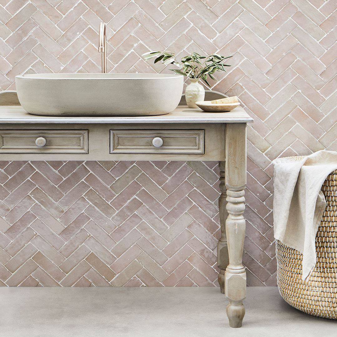 Beige and blush herringbone tile wall, creating a calm, minimalist design.