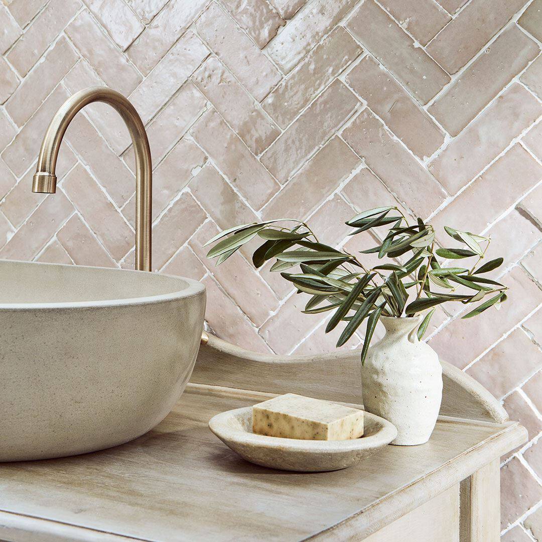 Beige and blush herringbone tile wall, creating a calm, minimalist design.