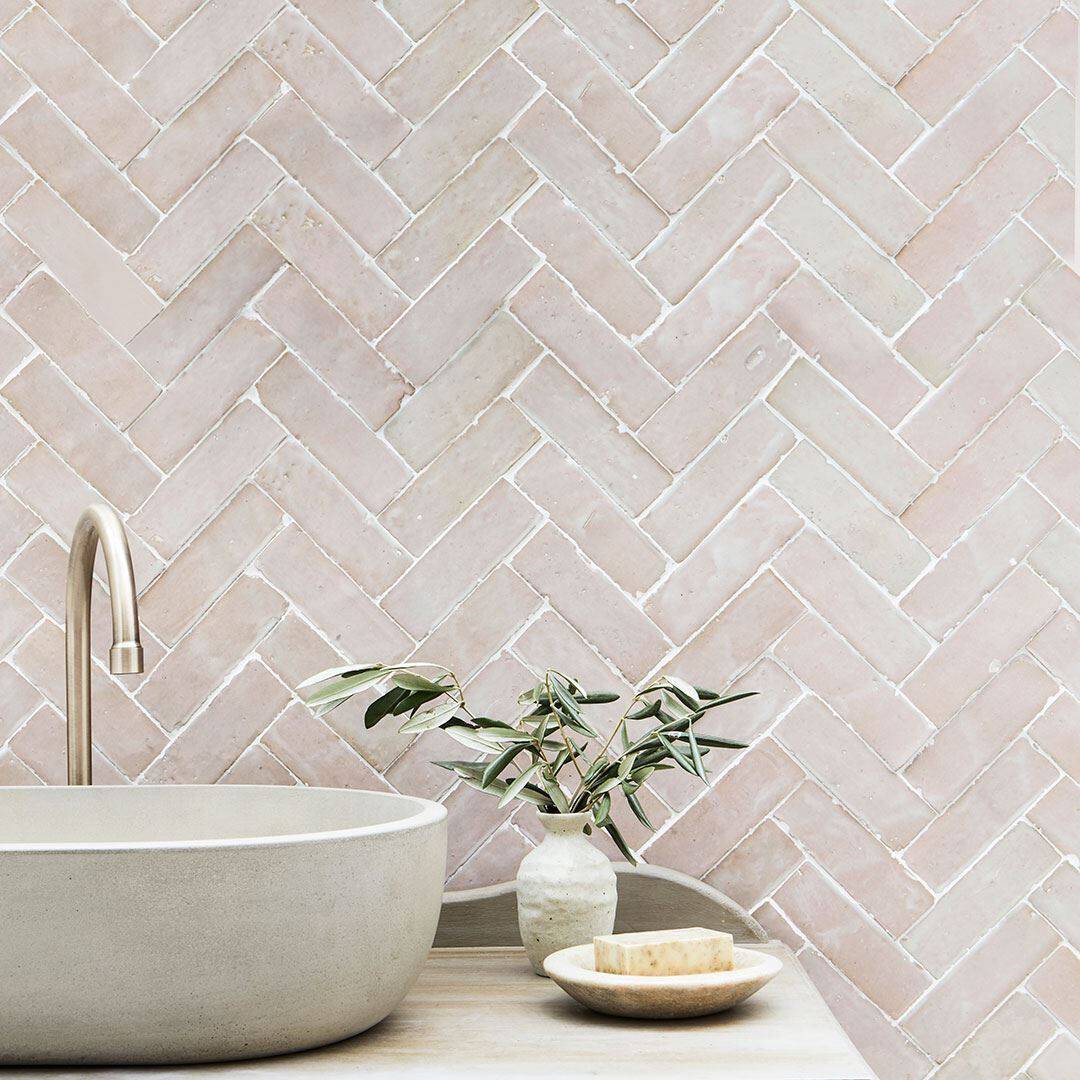 Beige and blush herringbone tile wall, creating a calm, minimalist design.
