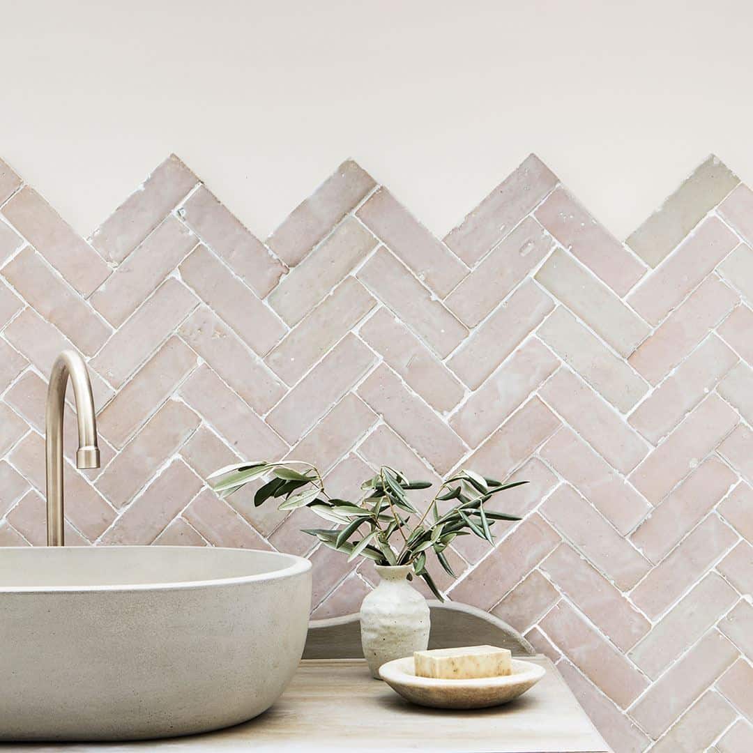 Beige and blush herringbone tile wall, creating a calm, minimalist design.