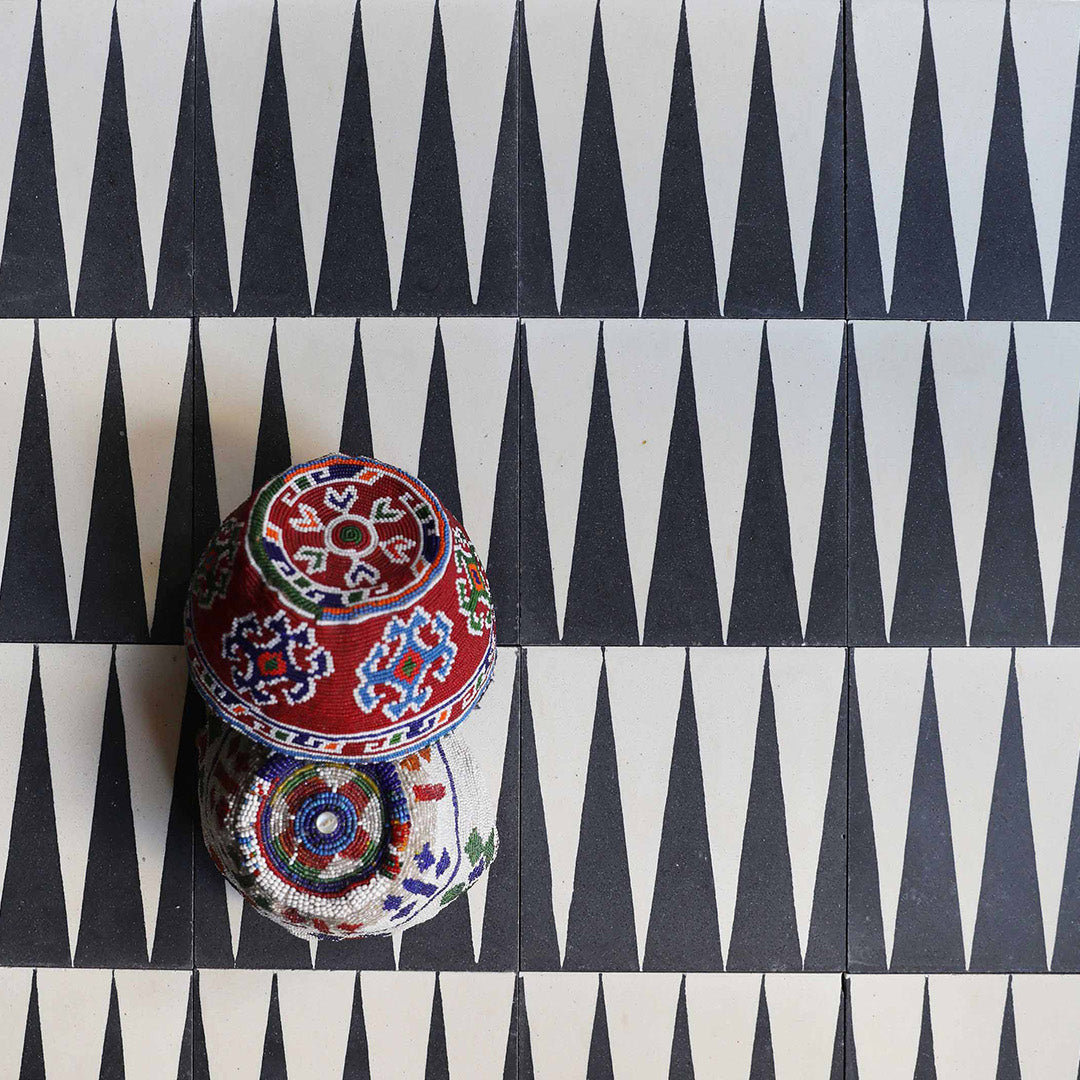 Decorative boxes with intricate patterns on a geometric black and white background