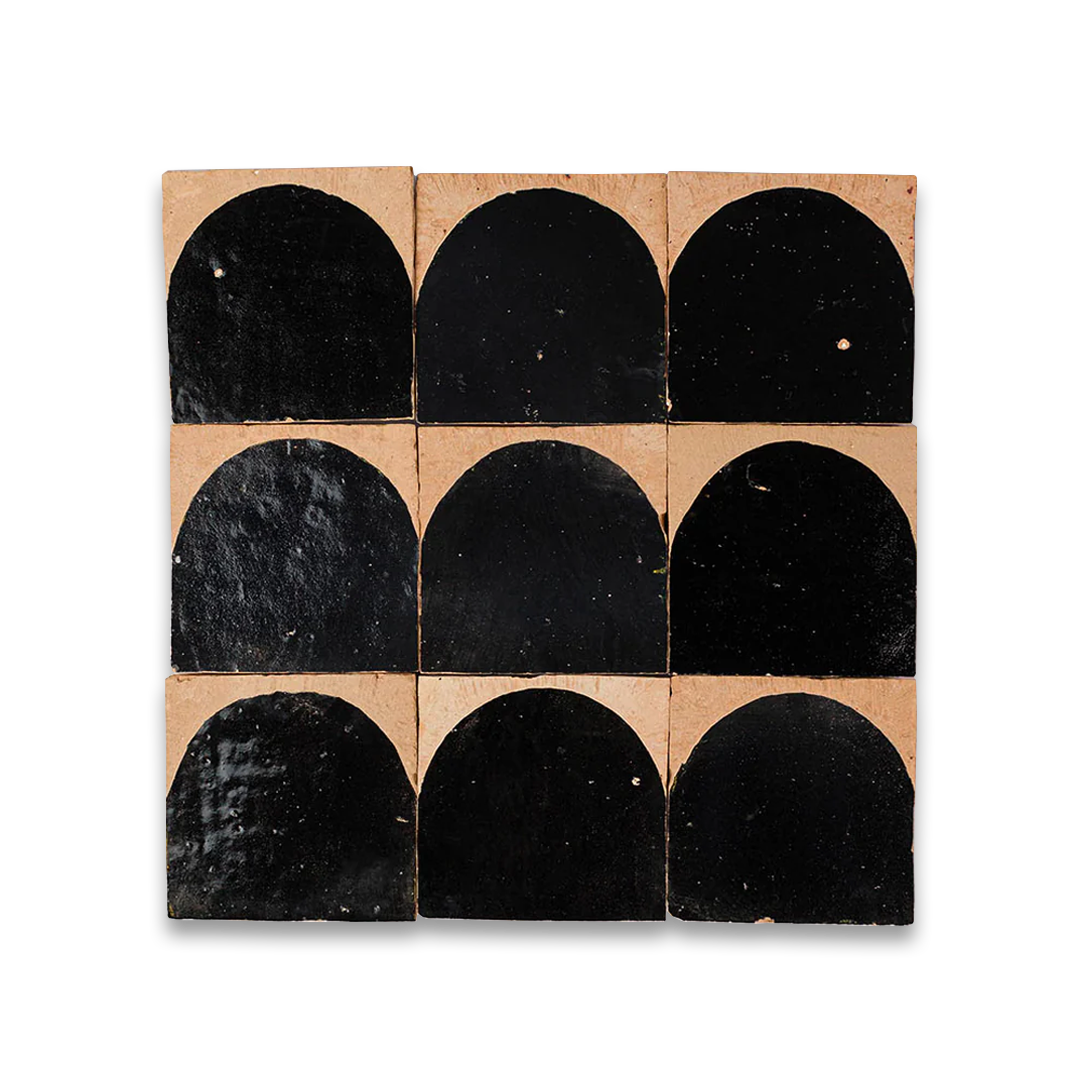 Nine black arch-shaped tiles on a cardboard backing