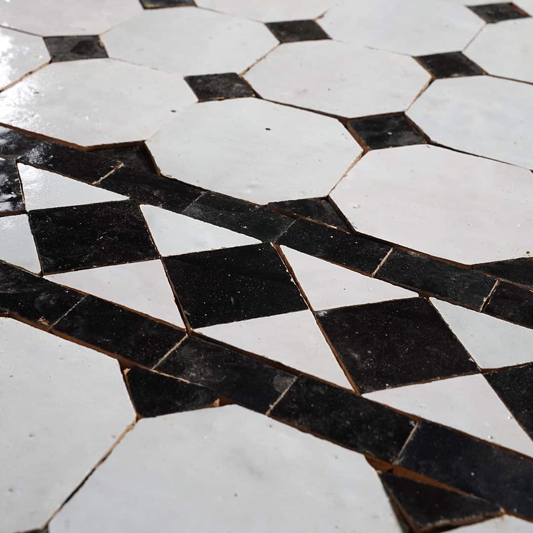 Decorative tile with black and white diamond pattern on a white background