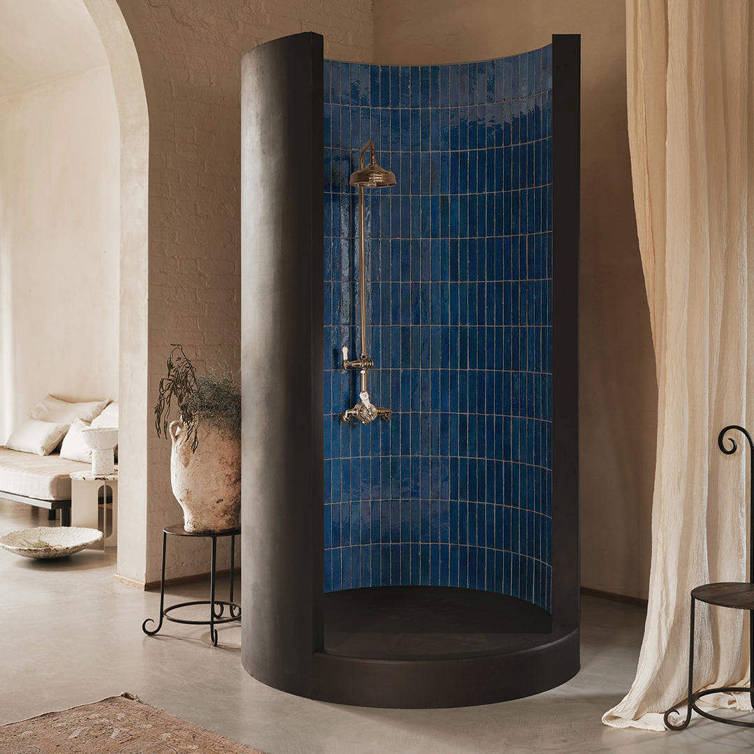 Modern shower enclosure with blue tiles in a bathroom setting