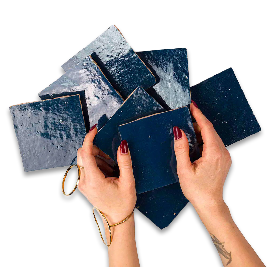 Hands holding blue marbled coasters on a white background