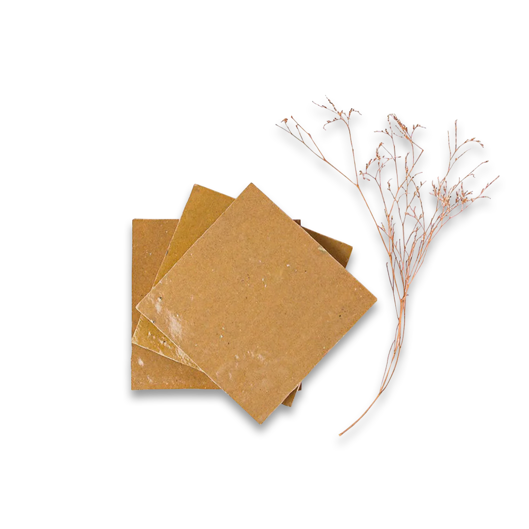 Three brown square soap bars on a white background with a dried plant branch.