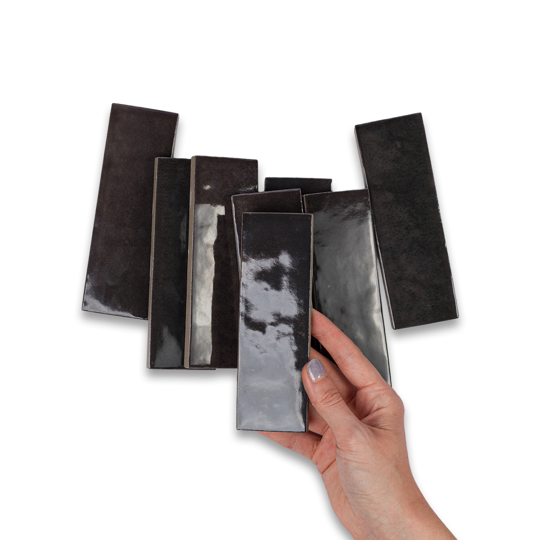 Hand holding a black rectangular object with a reflective surface against a white background