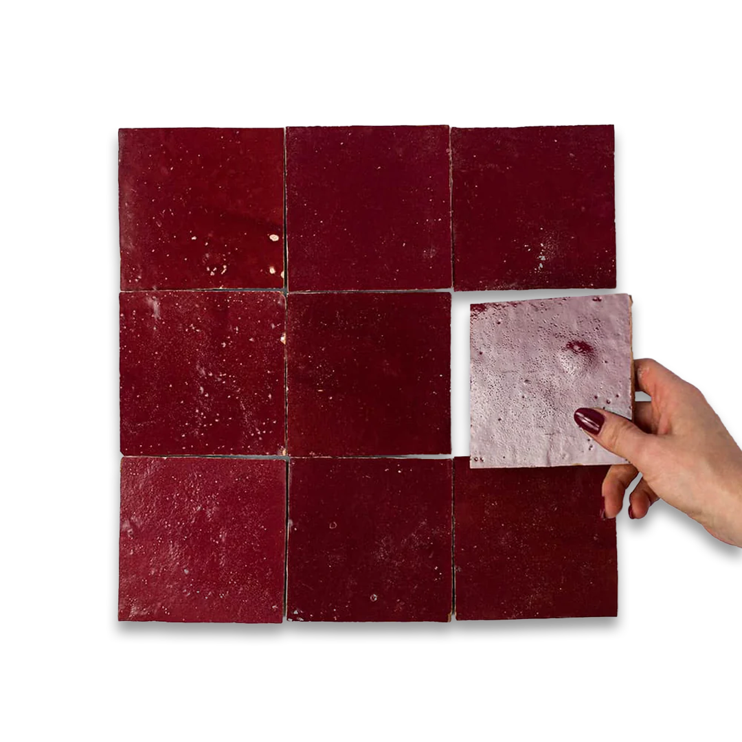 Red tiles with a hand holding one tile against a white background