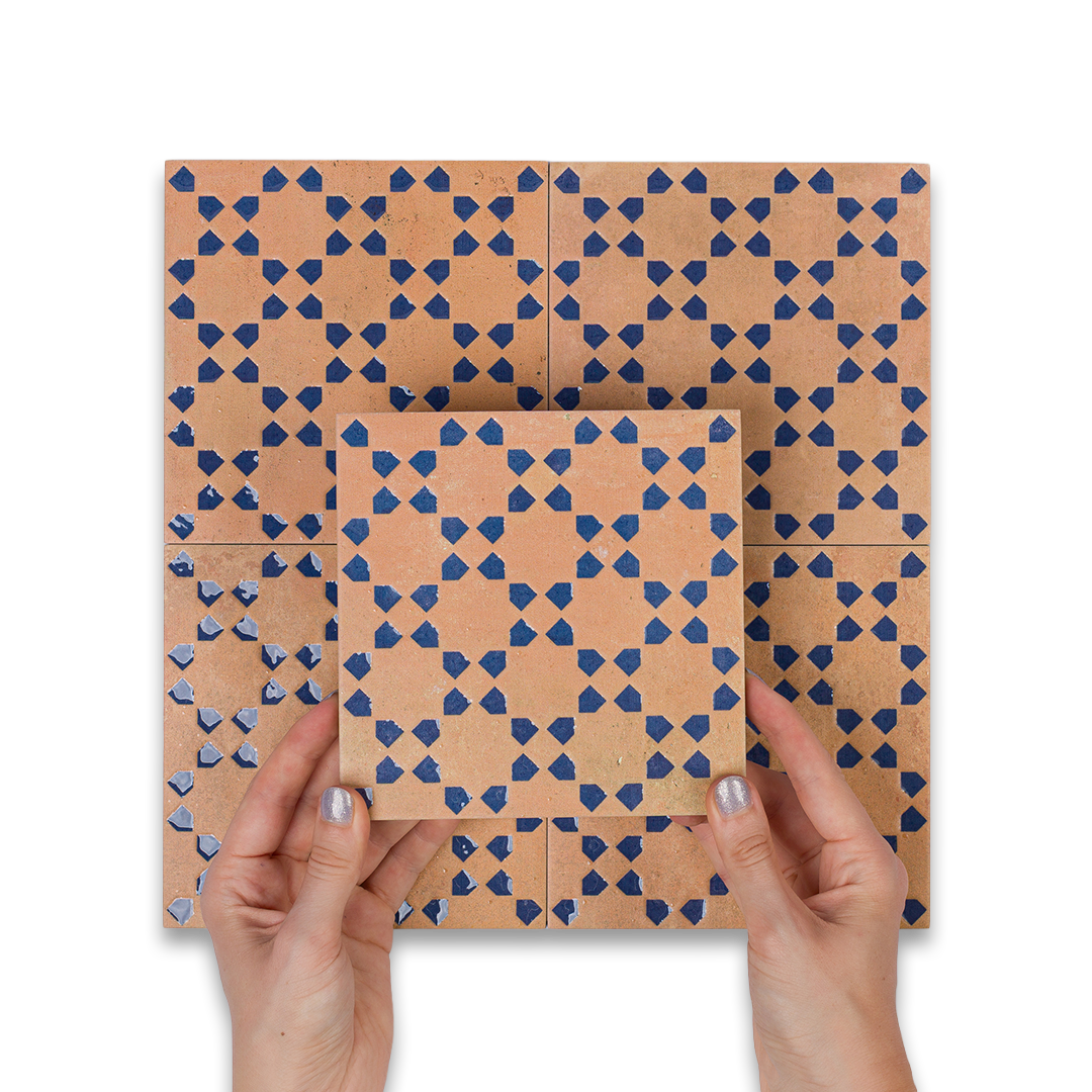 Hands holding a patterned cardboard box with geometric design on a white background