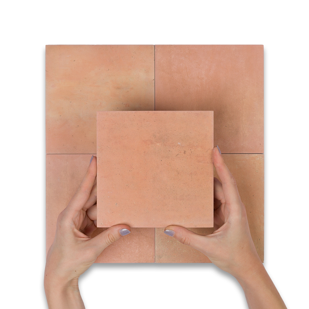 Terracotta tiles with a person holding one tile against a matching background