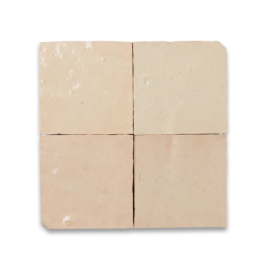 Four square tiles made of a beige material on a white background