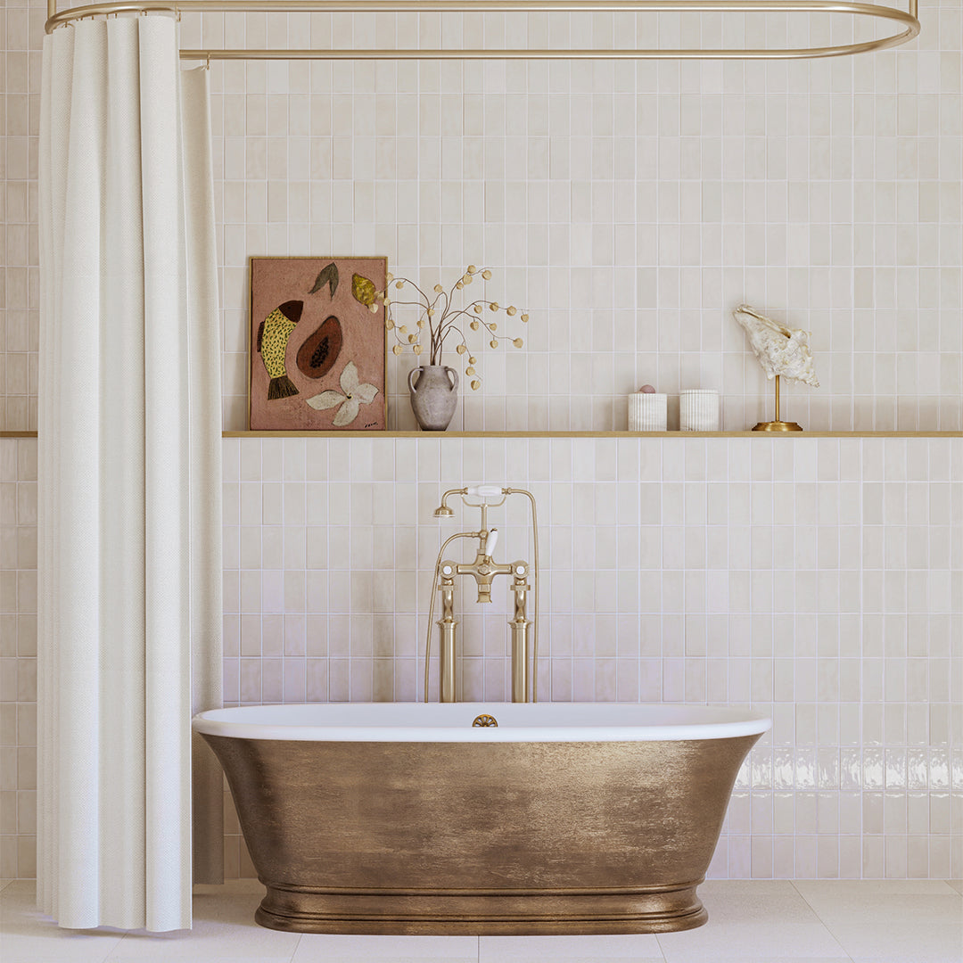 Bronze freestanding bathtub in a bathroom with tiled walls and decorative elements.