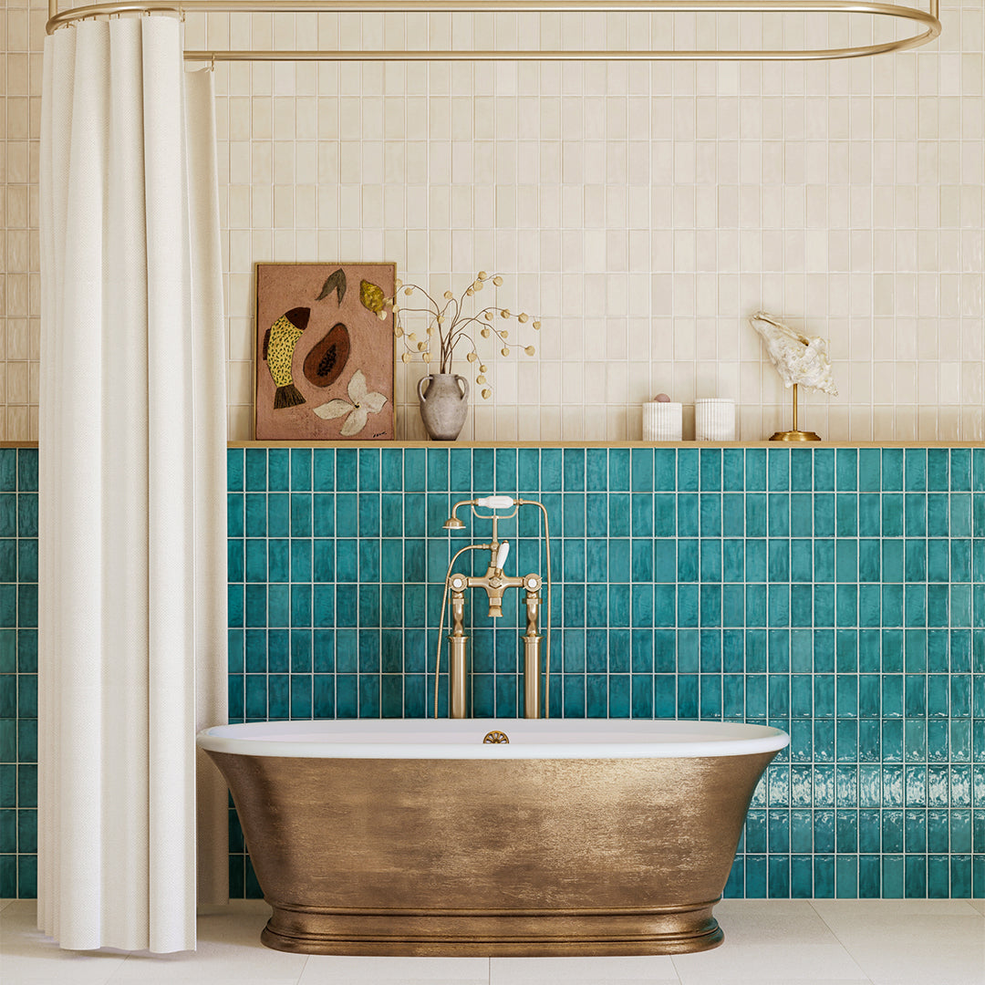 Bathroom with a gold freestanding bathtub, teal tiled wall, and decorative elements.