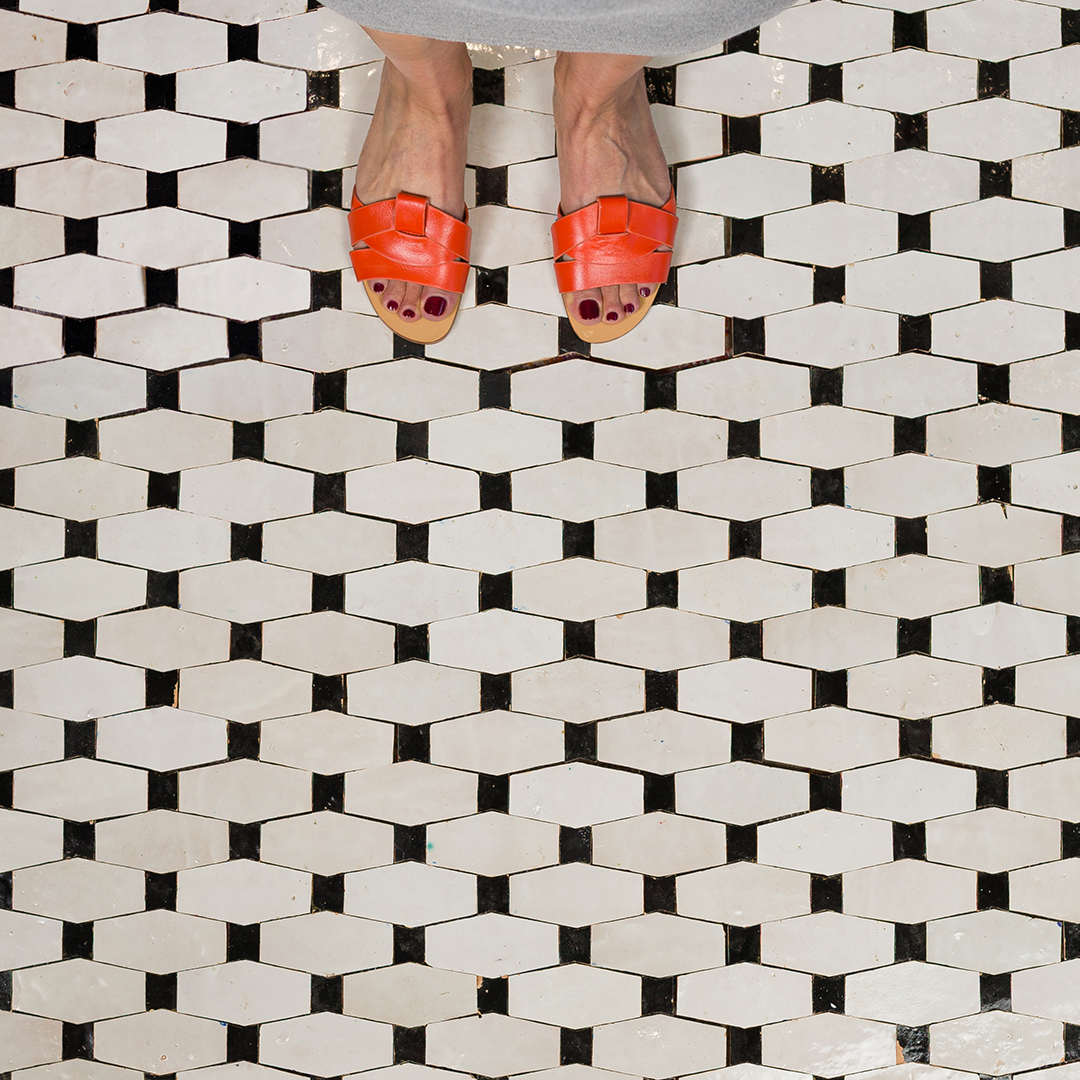 Geometric pattern of white elongated hexagonal tiles in staggered layout with black grout lines on transparent background.