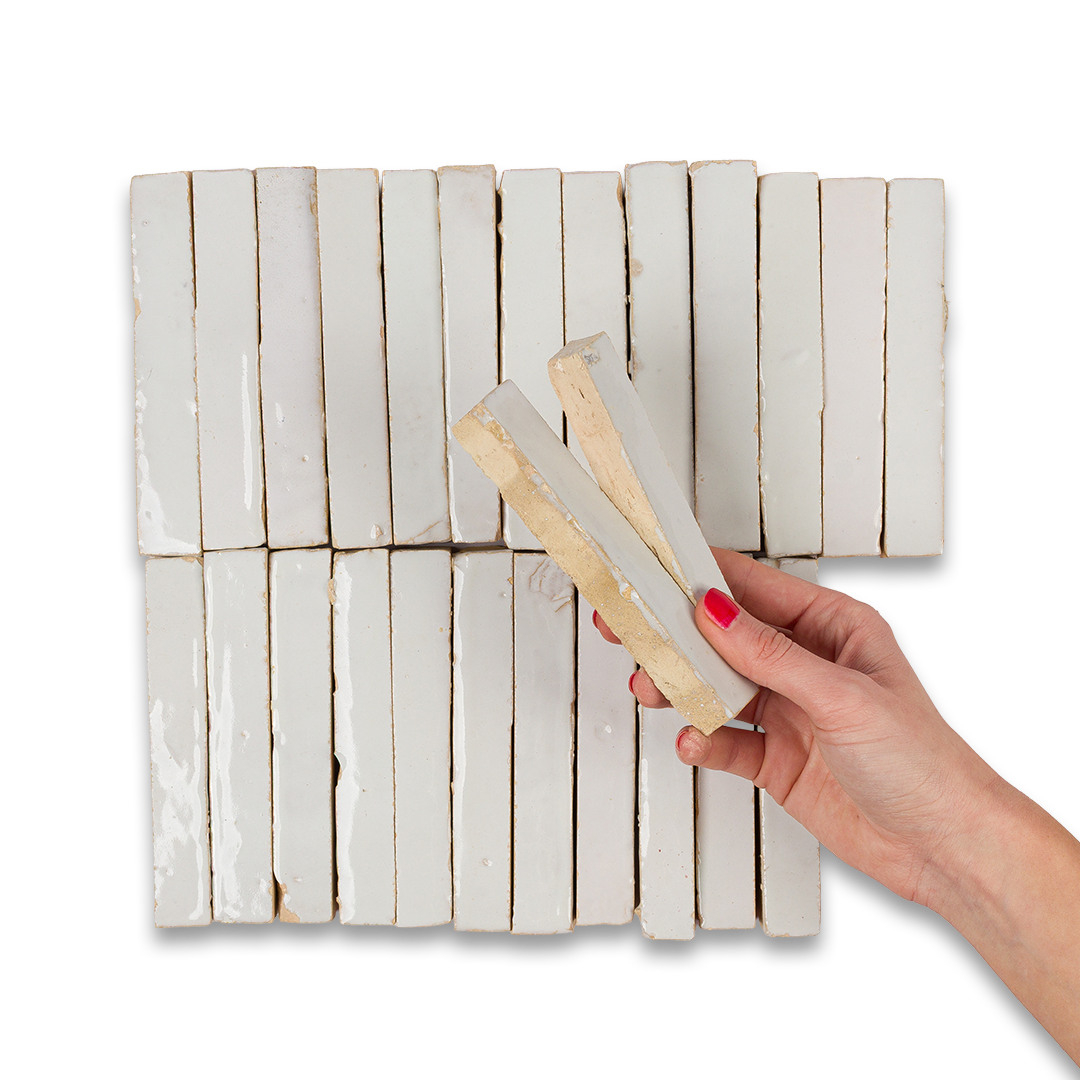  A person holding a square piece of white tile in their hand, showcasing its smooth surface and clean edges.