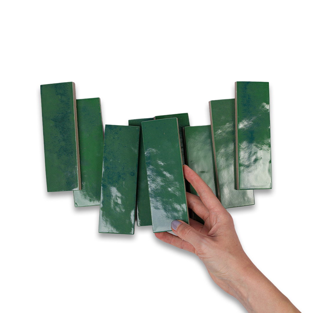 Hand holding a set of green rectangular objects against a white background
