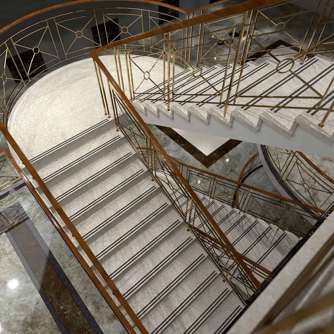 Luxurious staircase with marble steps, geometric metal railings, and polished stone flooring