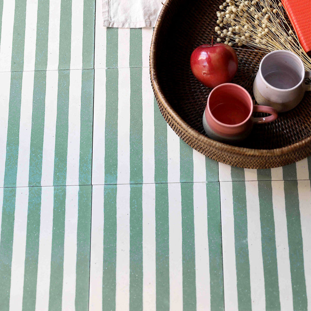 Square cement tile with alternating vertical green and white stripes, creating a clean, minimalist pattern.