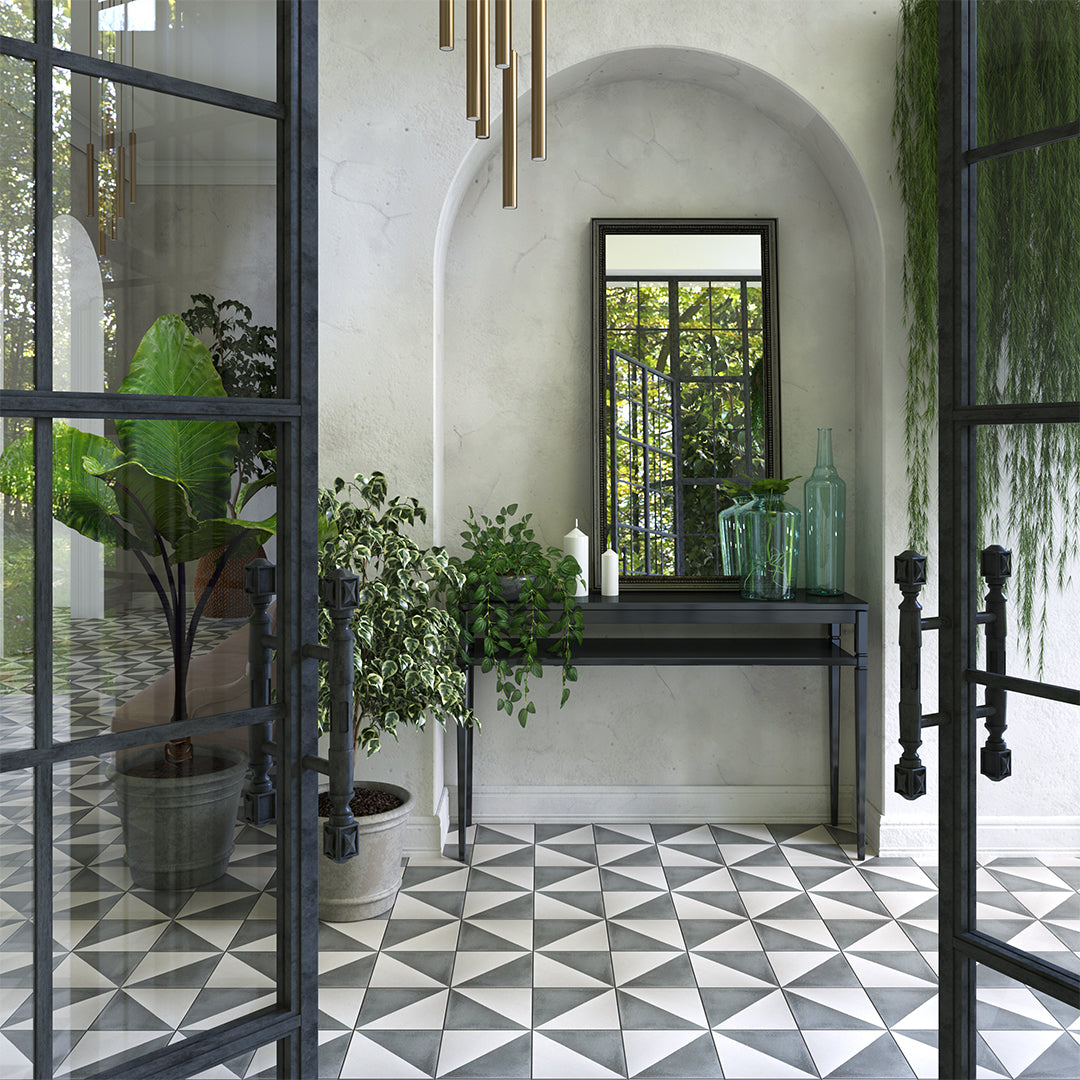 Modern interior with geometric tile floor, plants, and a mirror.