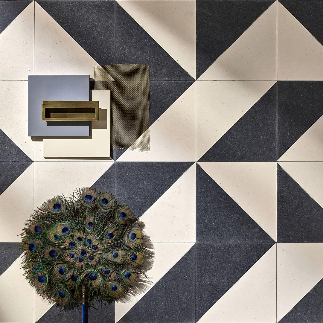 Square ceramic tile diagonally split into smooth off-white and speckled charcoal black halves, minimalist geometric design.