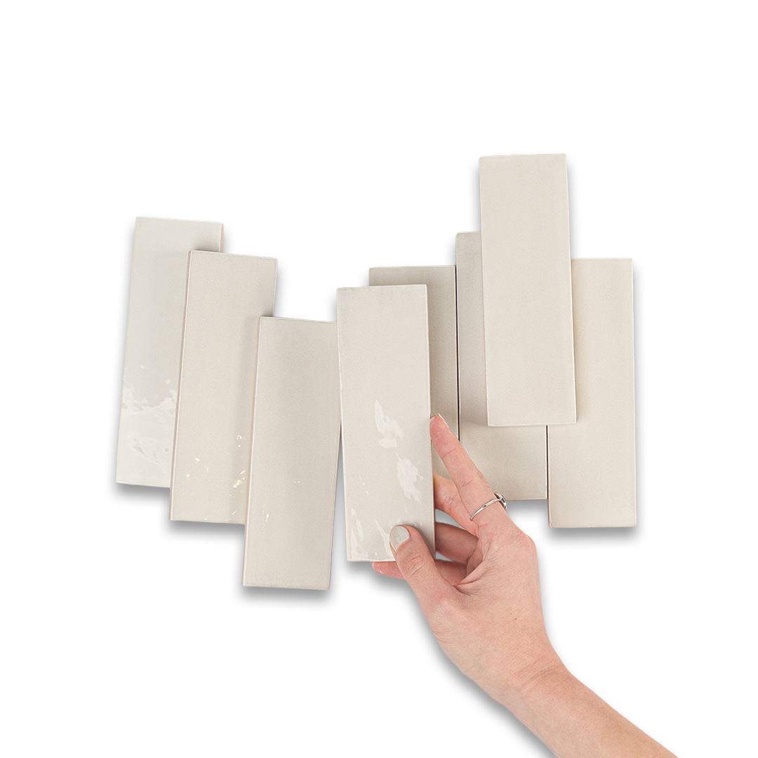 Hand holding a set of beige color swatches against a white background