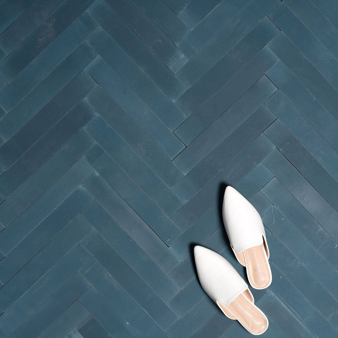 Rectangular blue metro cement tiles arranged in a herringbone pattern with a smooth matte finish, ideal for modern flooring, wall cladding, and contemporary interior design applications.