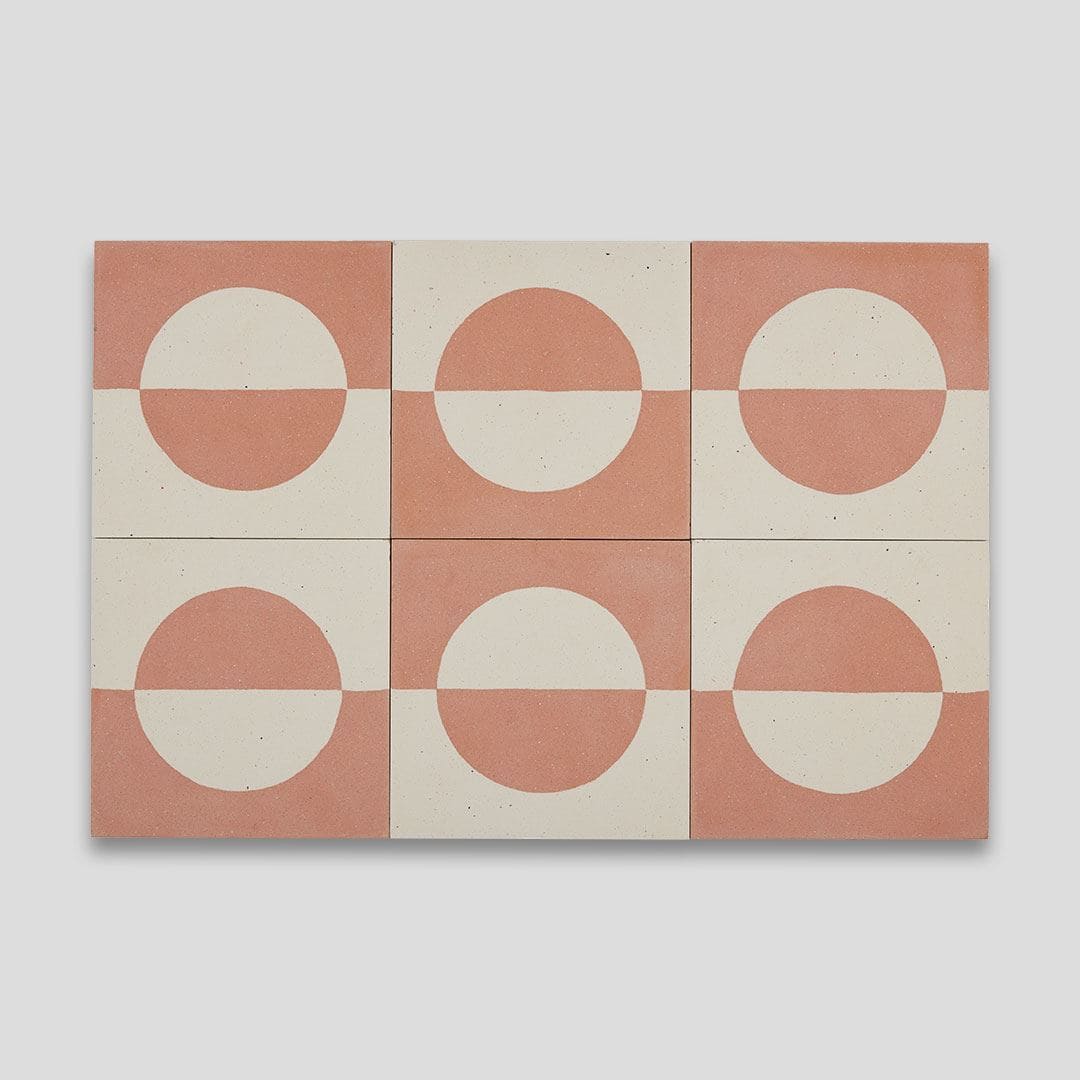 A square cement tile featuring a minimalist geometric design with a terracotta and cream color palette, displaying a half-circle pattern resembling a rising or setting sun.