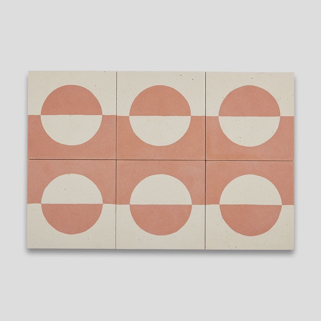 A square cement tile featuring a minimalist geometric design with a terracotta and cream color palette, displaying a half-circle pattern resembling a rising or setting sun.