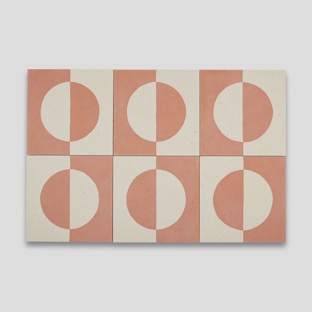 A square cement tile featuring a minimalist geometric design with a terracotta and cream color palette, displaying a half-circle pattern resembling a rising or setting sun.