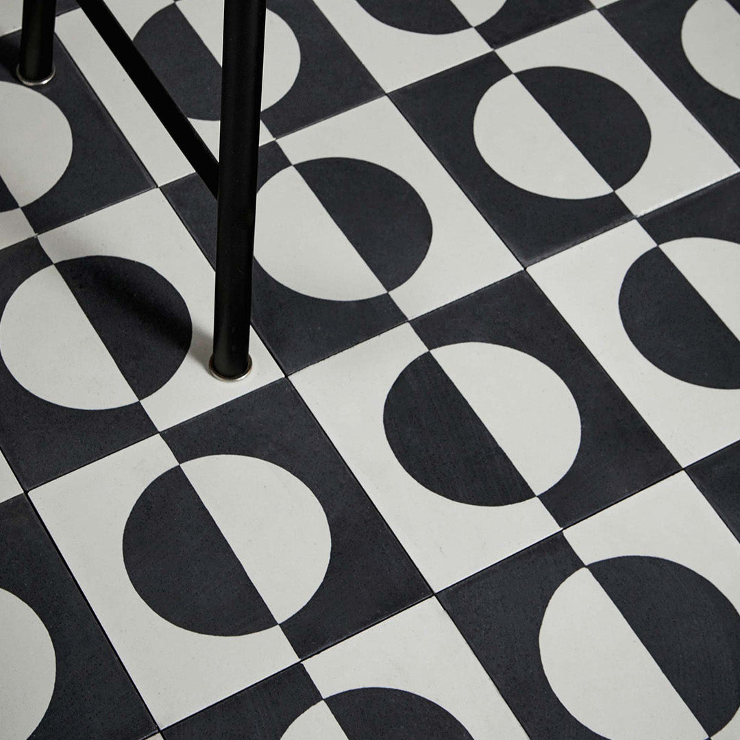 Black and white geometric cement tile featuring a bold circular half-moon pattern, minimalist modern design, matte finish, ideal for contemporary flooring, wall décor, and architectural interior applications.