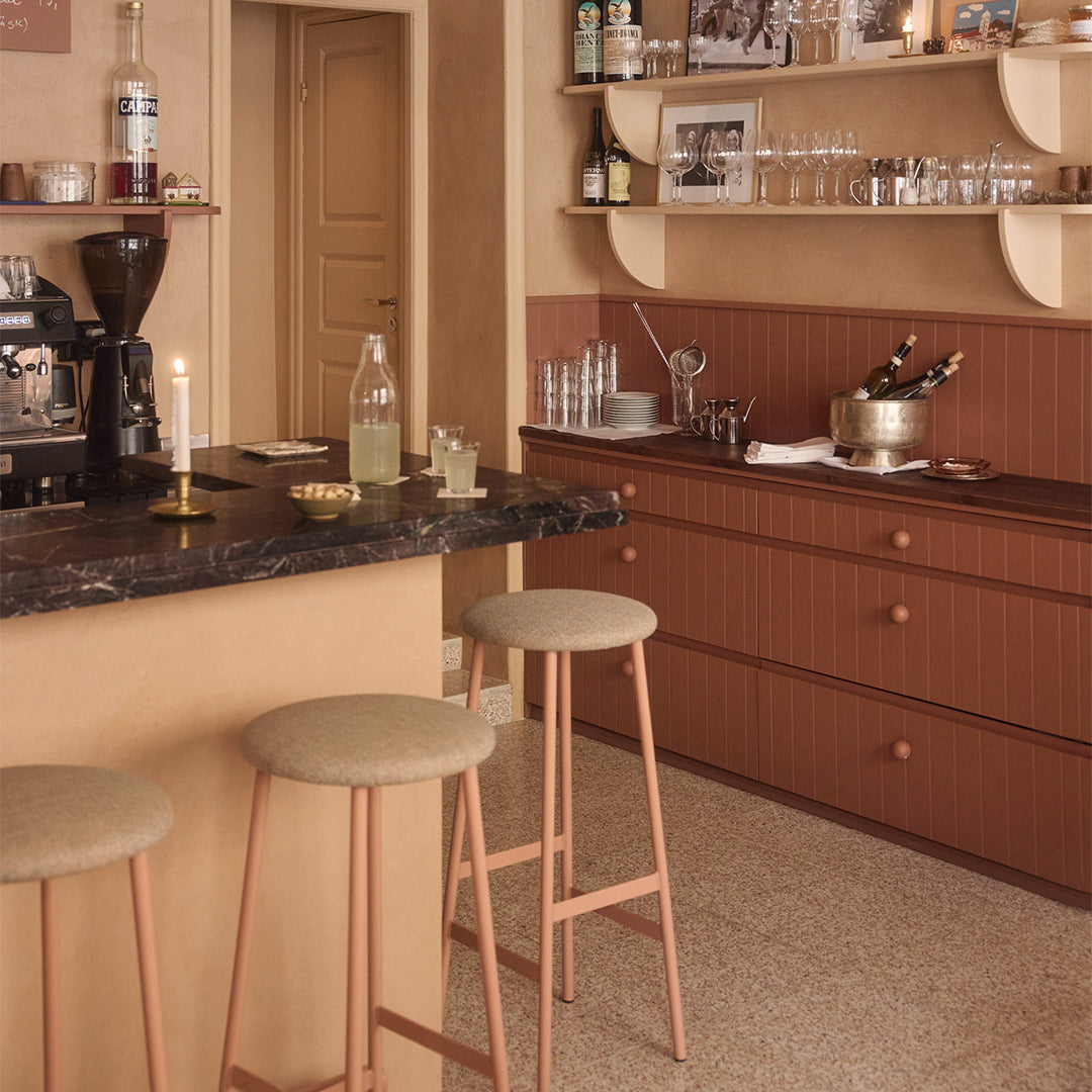 Modern kitchen with bar area, stools, and various appliances.