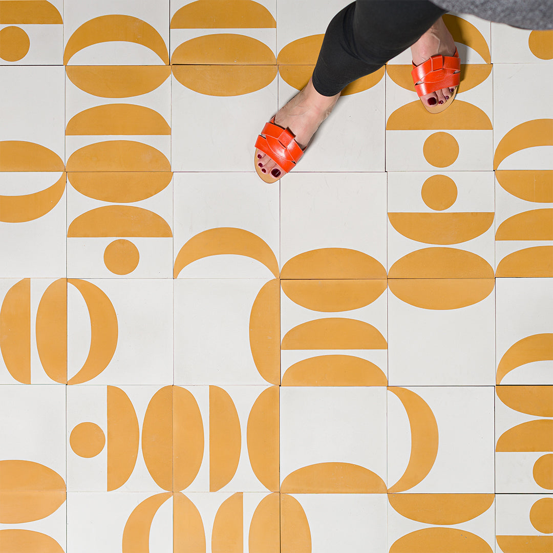 Geometric cement tile design featuring mustard yellow and white abstract shapes with semi-circles and curves, ideal for modern flooring, wall decor, or contemporary Mediterranean interiors.