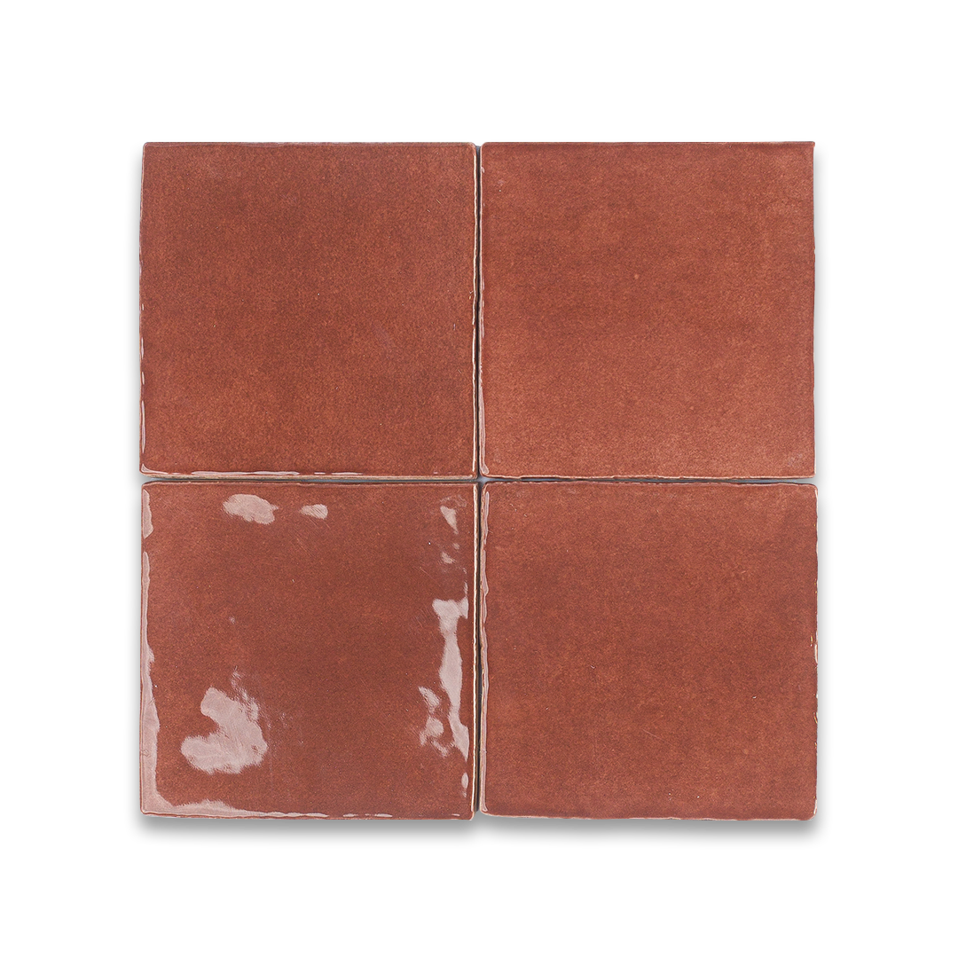 Four square tiles with a red-brown color on a white background