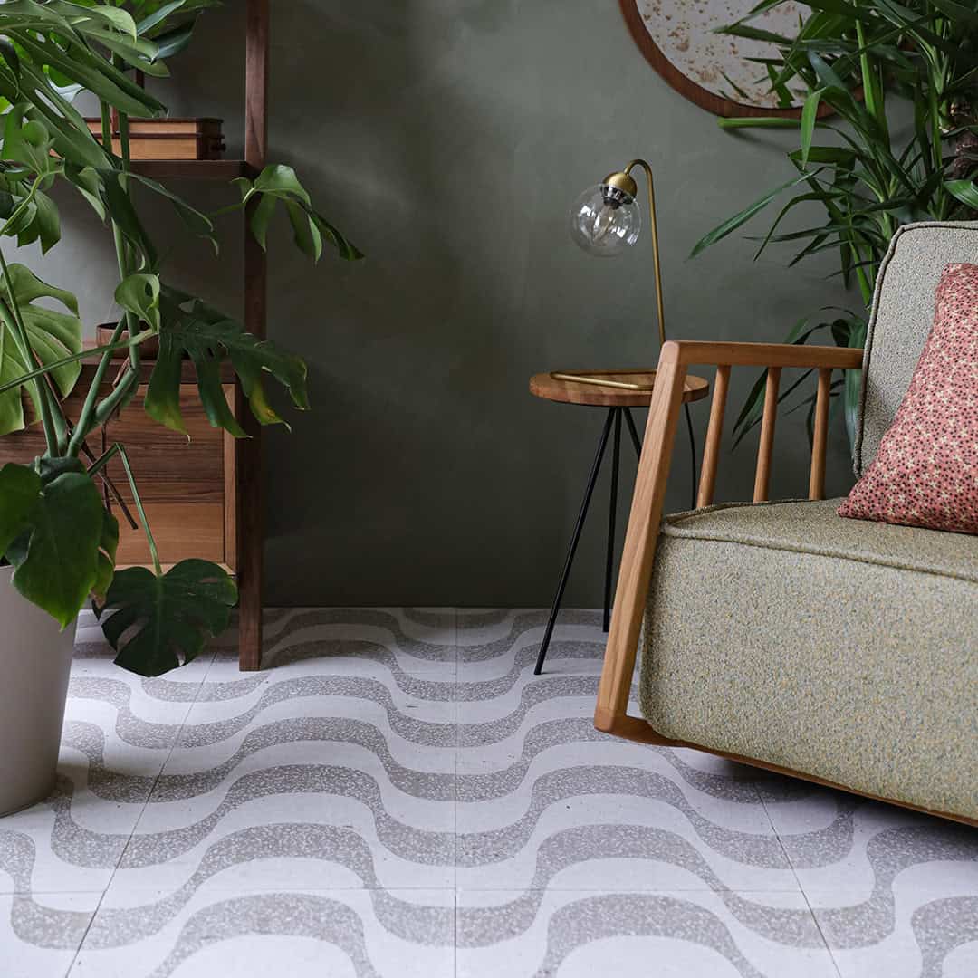 A square cement tile featuring a white background with curved beige wave-like patterns filled with small white speckles, creating a soft, organic, and modern decorative design.