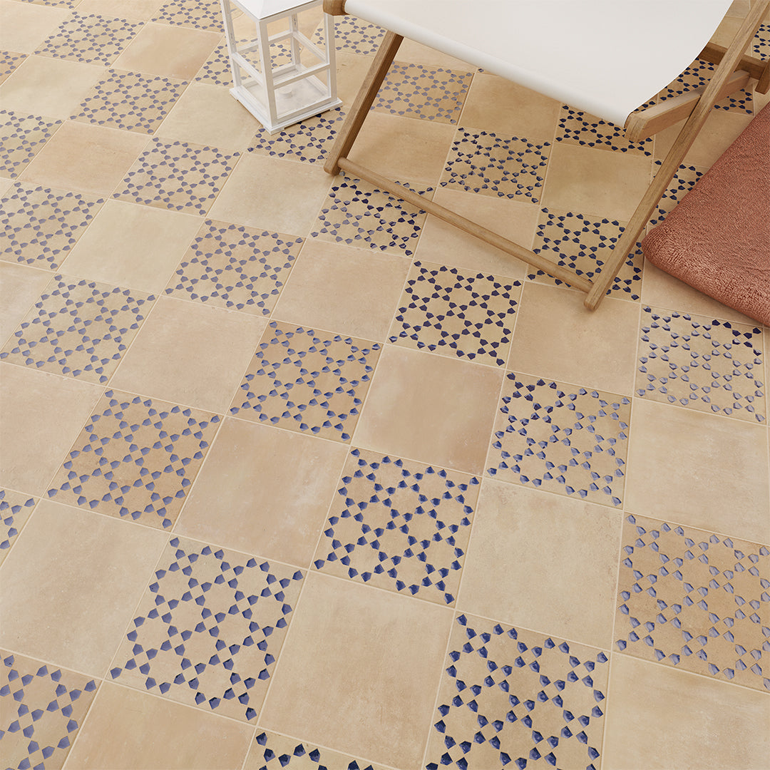 Patterned tiles on a floor with a chair and rug in the background