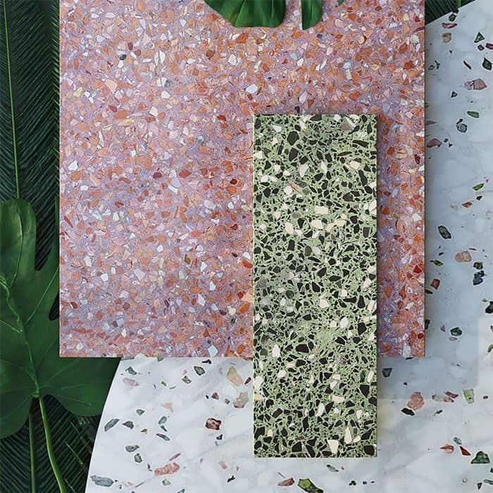 Layered terrazzo tile samples in green, pink, and white tones with tropical leaves framing the composition.