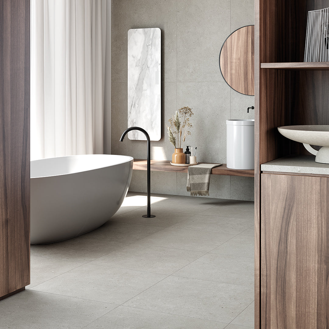 Modern bathroom with freestanding bathtub, wooden shelves, and marble mirrors.