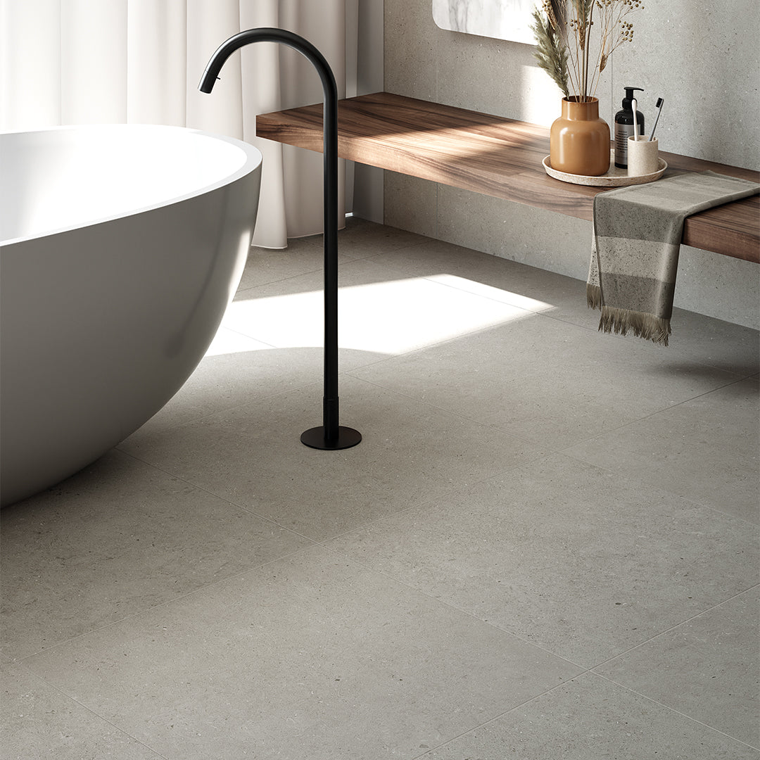 Bathroom with a freestanding bathtub, wooden bench, and modern fixtures.