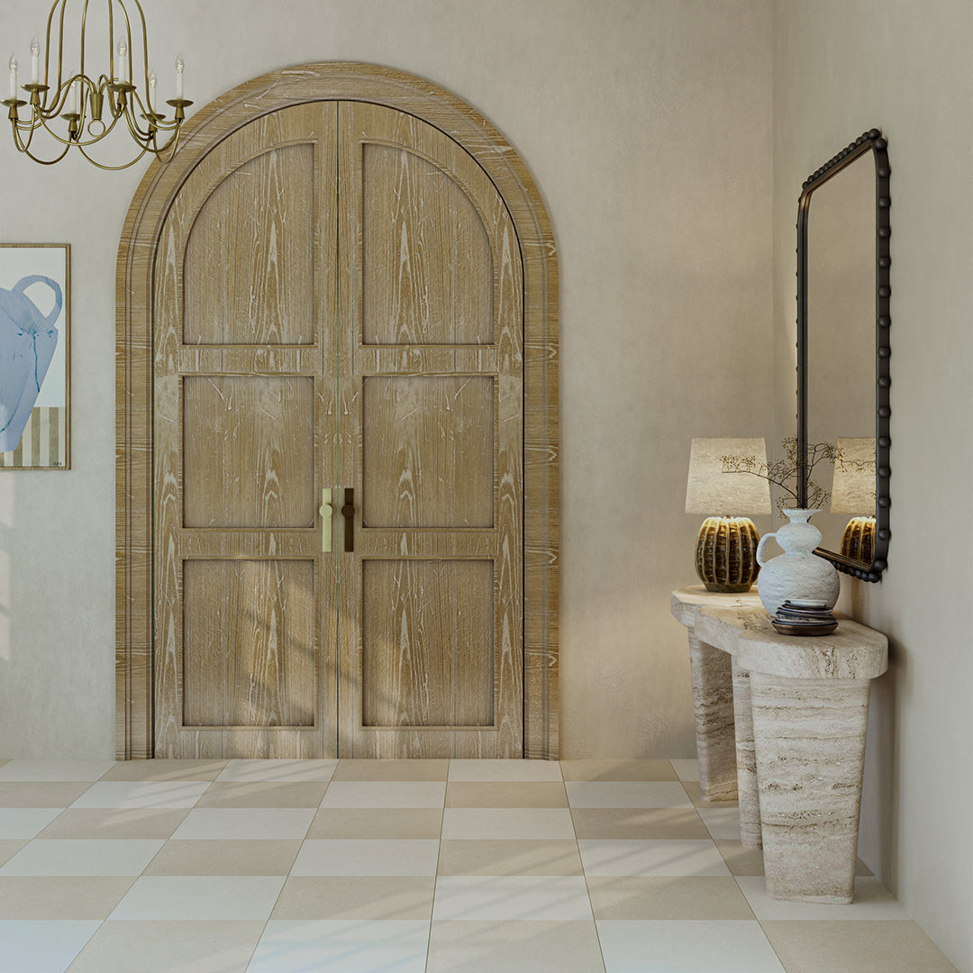 Wooden door in a room with a lamp and mirror on a side table.