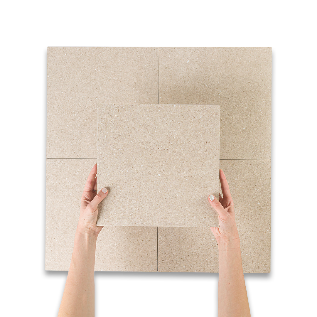 Beige tiles with a person's hands holding one tile on a white background