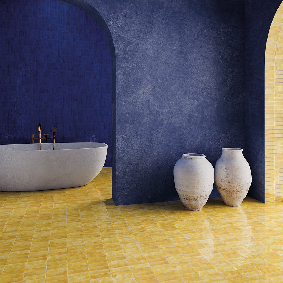 Bathroom interior with a blue wall, yellow tiled floor, and two vases.