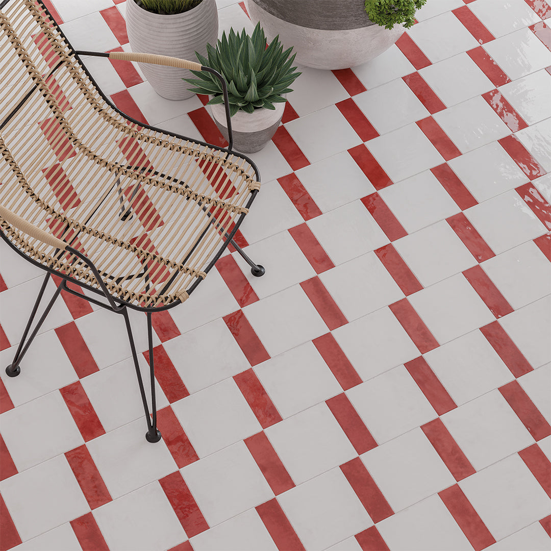 Red and white checkered tile pattern with a wicker chair and potted plants.
