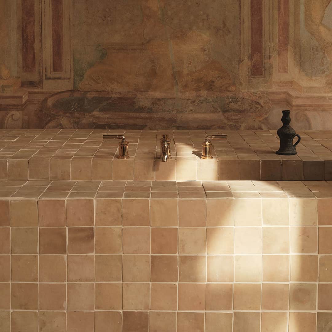 A tiled sink or countertop made of square beige tiles with a matte finish. 