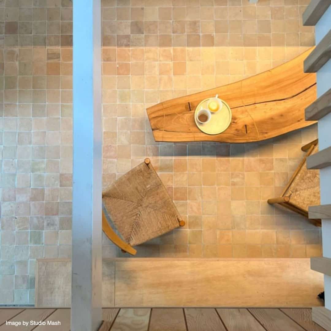 Overhead view of a small interior with a tiled floor of beige and light brown squares.