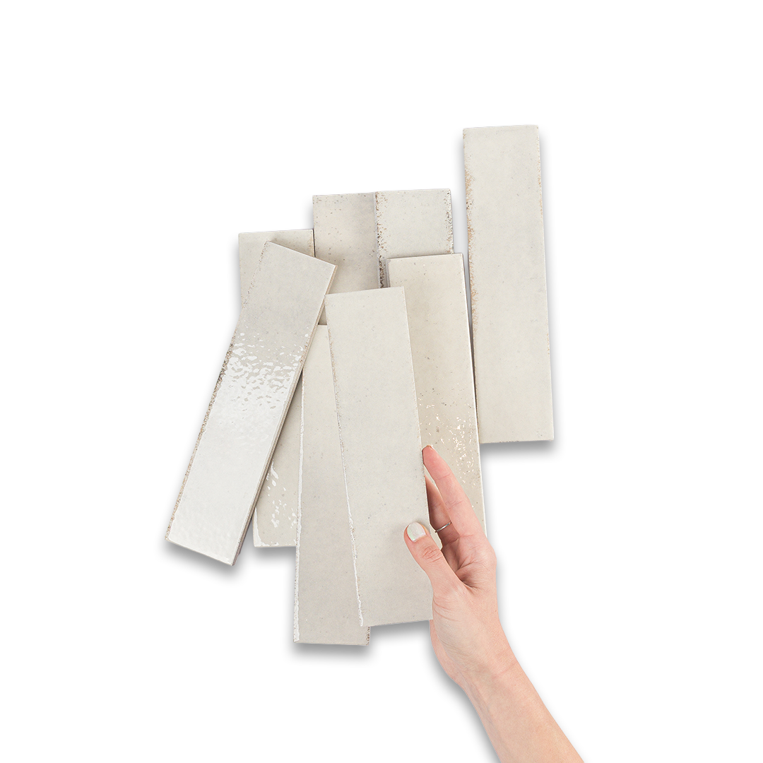 Hand holding a set of beige color swatches on a white background