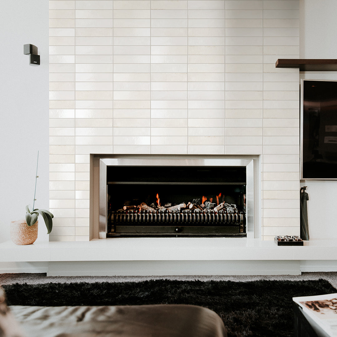 Modern fireplace with white tiled wall and minimal decor