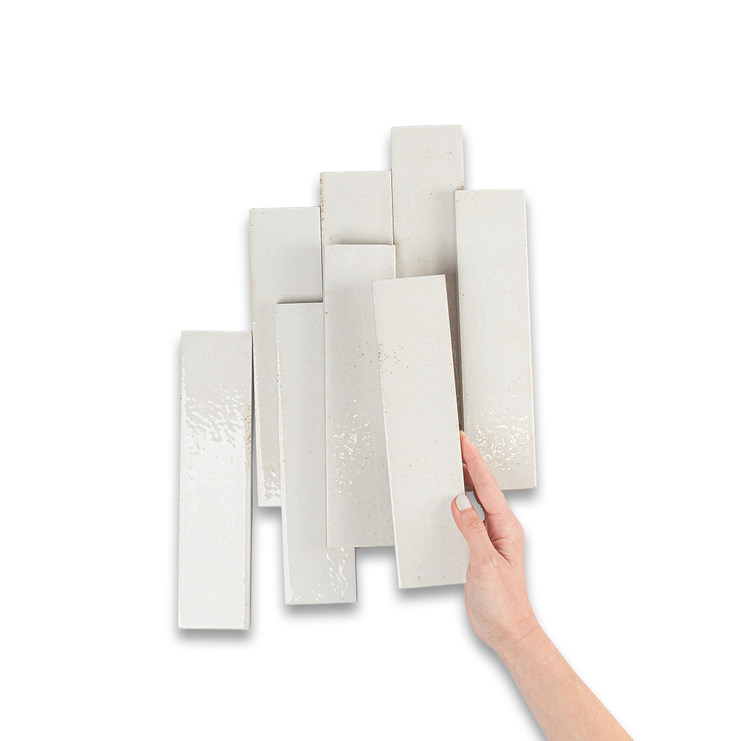 Hand holding a white tile against a white background